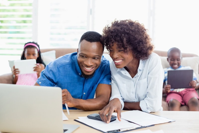 Couple sitting at table and calculating bills.