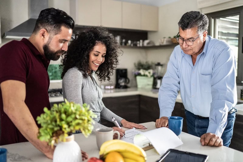 Adult couple filling document in the kitchen at home.